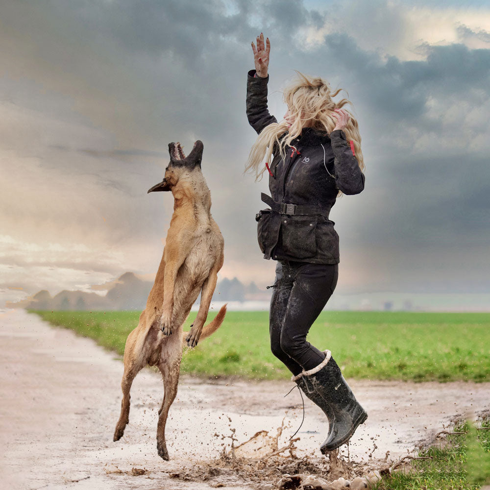 Hundeführerin in IQ Multifunktionsjacke beim Training mit Malinois bei Regen