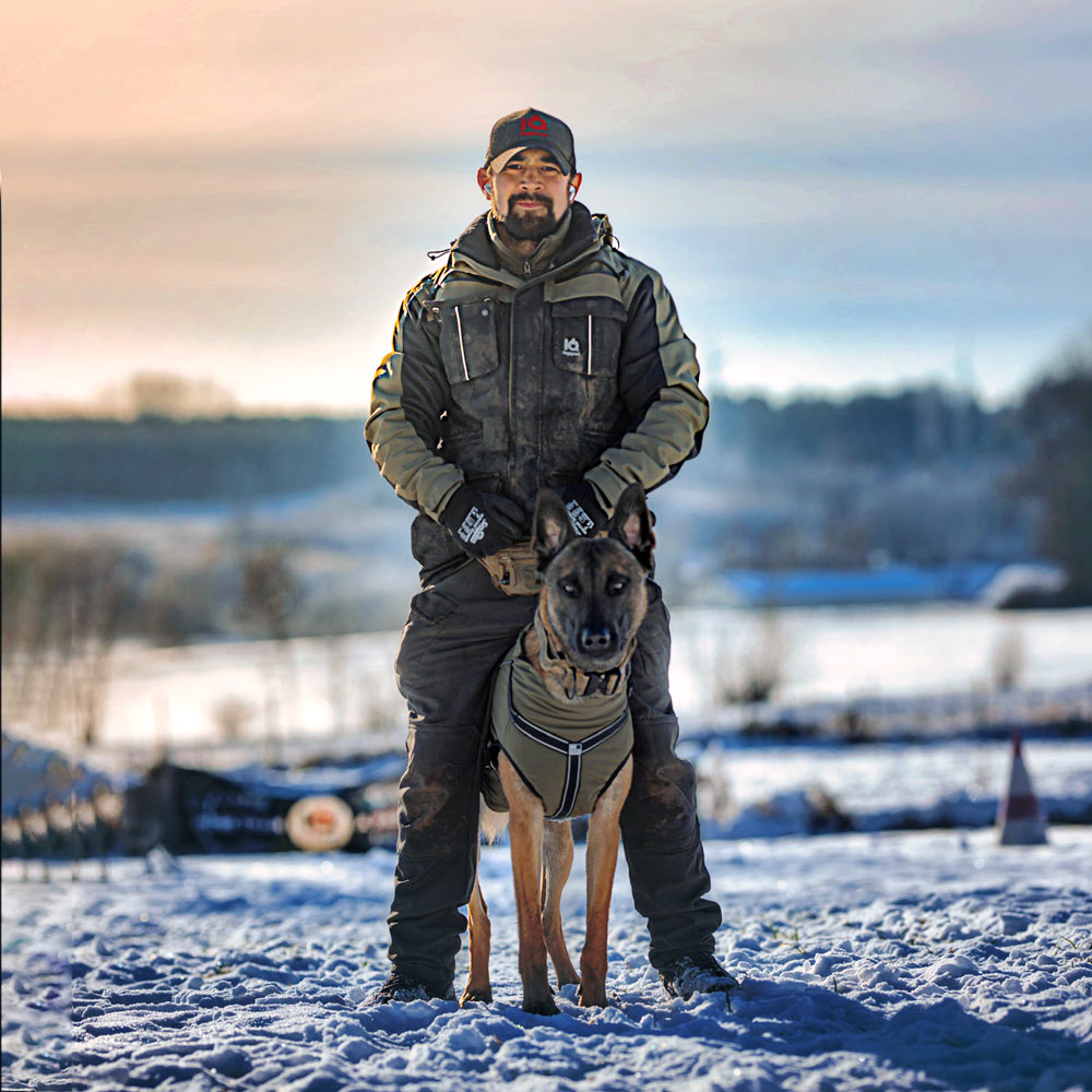 Hundeführer mit Malinois in oliver Hundesport-Jacke im Schnee